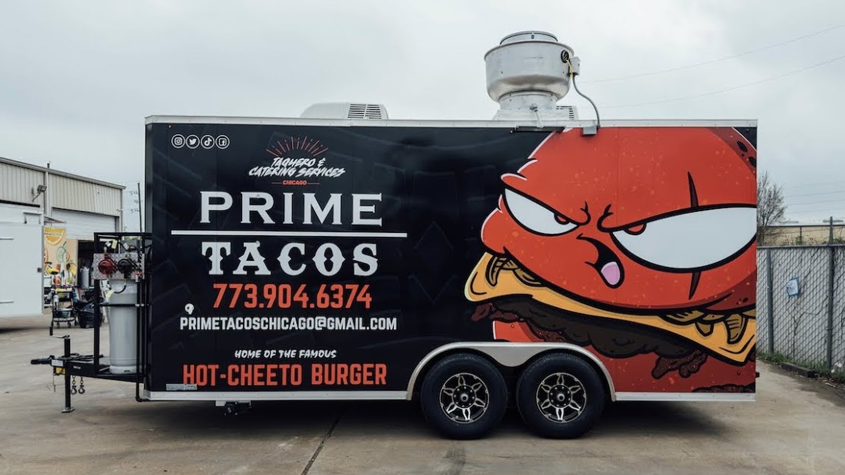 The Prime Tacos trailer with the angry burger mascot wrap and the booking number painted on the side