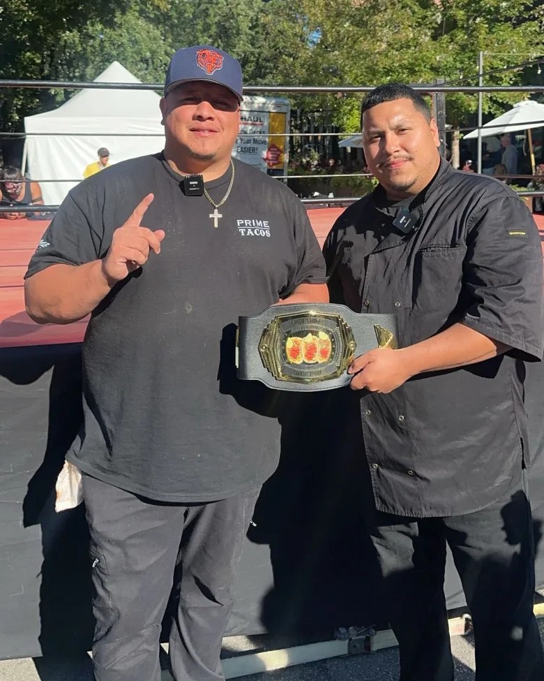 Anthony Solis and Eric Cardenas holding the Lakeview Taco Fest championship belt at the festival