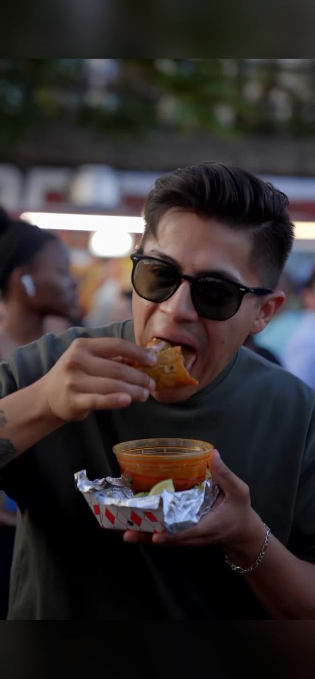 A customer eating at the Prime Tacos stand at Lollapalooza